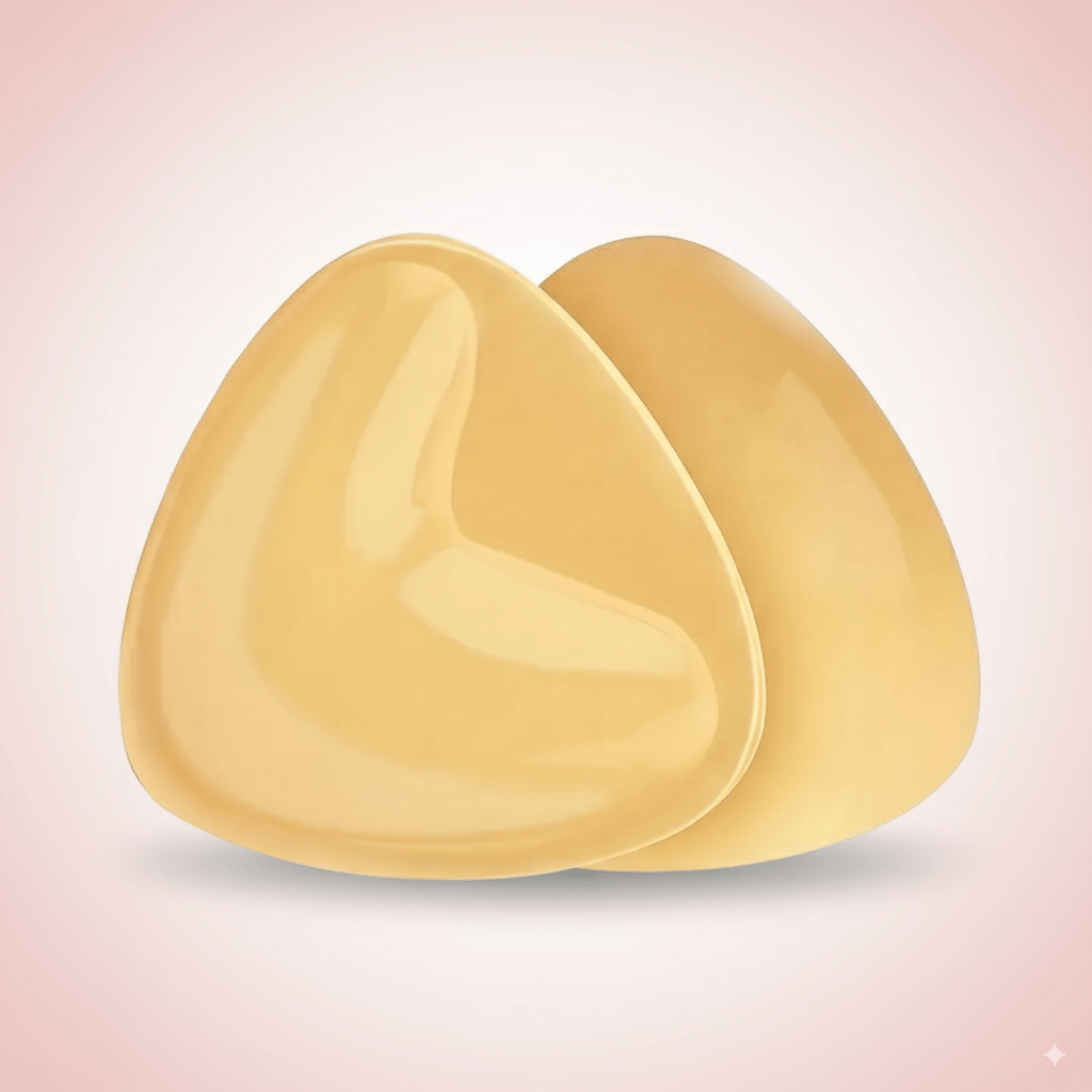 Two push up silicone bra insert pads on a gradient pink background